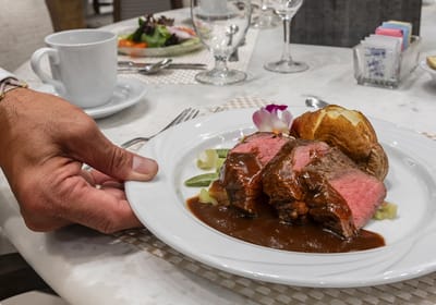 A server presenting a plated meal in the dining room