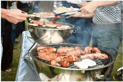 Barbecue preparation with grilled meats outdoors.