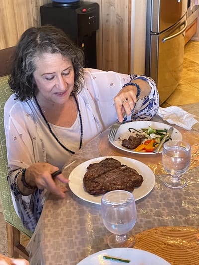 Woman enjoying a meal at a dining table.