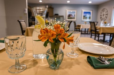 Dining table set with flowers and beverages.