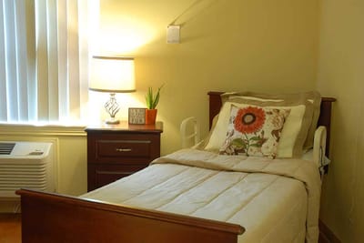 Cozy resident room with a bed and lamp