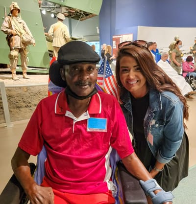 Resident and staff member smiling together.