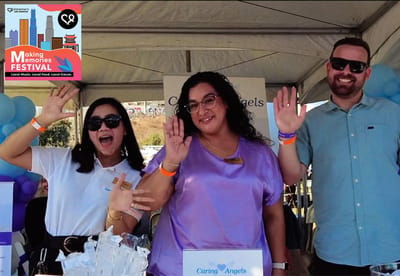 Staff members waving at a community event booth