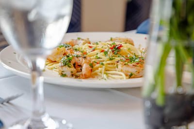 Close-up of a gourmet shrimp pasta dish on a dining table
