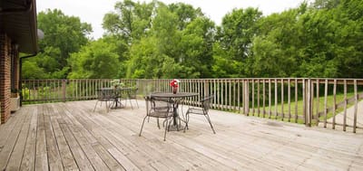 Outdoor deck area with tables and chairs surrounded by trees