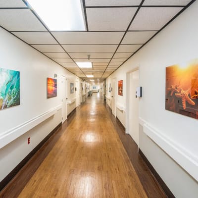 A well-lit corridor displaying artwork in a senior facility