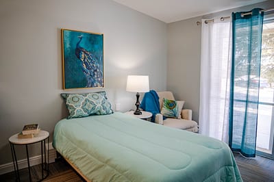 Bright private resident room with peacock art and chair