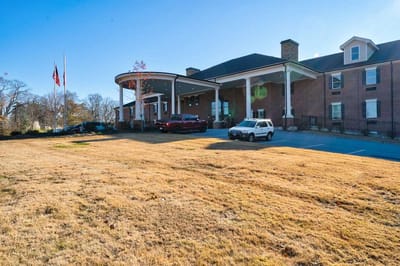 Exterior view of a senior living facility with vehicles