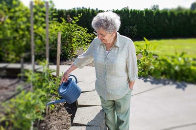 Senior woman watering a garden