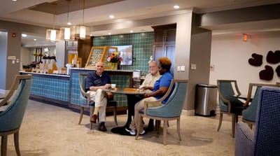 Residents and staff engaged in a conversation in the common area