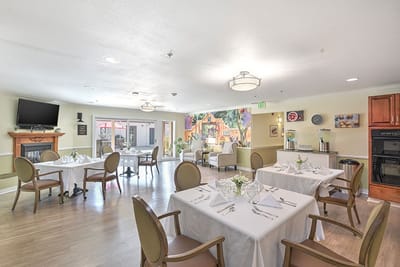 Dining area with elegantly set tables and mural painting