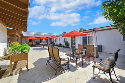 Outdoor patio area with red umbrellas and seating