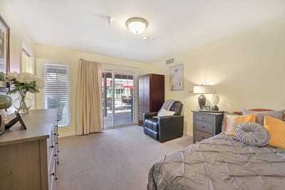 Brightly lit interior of a resident room with furniture