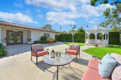 A serene outdoor seating area with a gazebo and garden