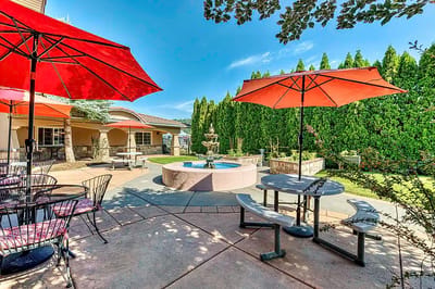Outdoor patio area with red umbrellas and fountain