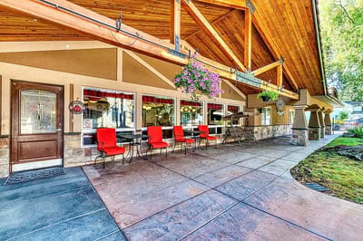 Outdoor seating area with red chairs and hanging plants