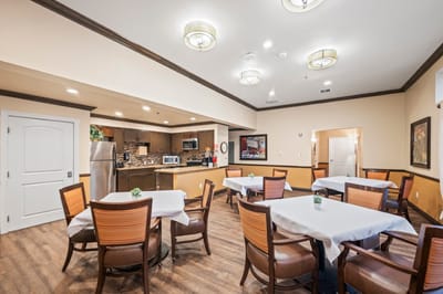 Dining area with tables and kitchen in the background