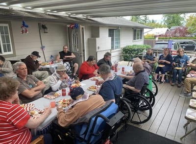 Residents enjoying a meal outdoors at a community event.