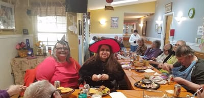 Residents enjoying a lively meal celebration.