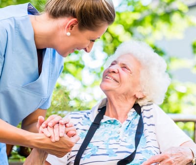 Visiting Angels Living Assistance Services, home care in Sterling Heights, MI — Caregiver holding hands with a smiling elderly woman