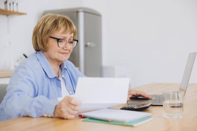 Senior woman reviewing documents at a desk