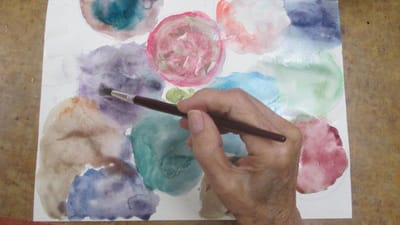 An elderly person painting with watercolors