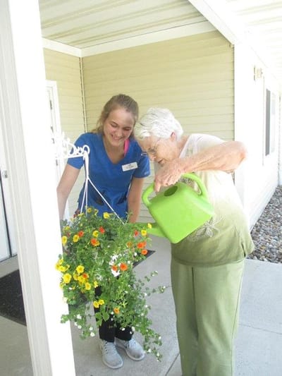 Resident and staff member gardening together