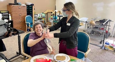 A staff member assisting a resident with an activity