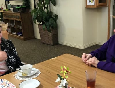 Residents enjoying tea and conversation at a common table