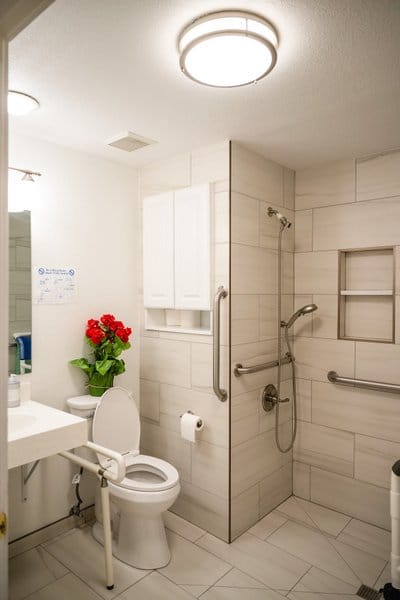 Modern assisted living bathroom with grab bars and flower decor