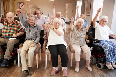 Residents enthusiastically raising their hands in a common area