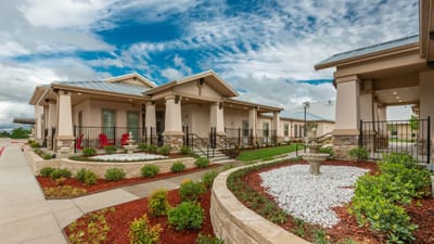 Exterior view of a senior living facility with gardens