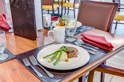 Plated meal with steak and asparagus in a dining room