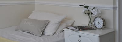 Cozy bedroom with a clock, flowers, and soft pillows