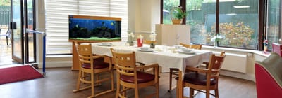 Dining room with a table set for meals and an aquarium