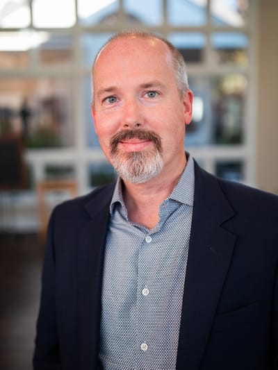 A man in a blazer posing indoors