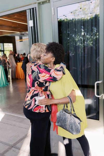 Two women hugging in a social event setting
