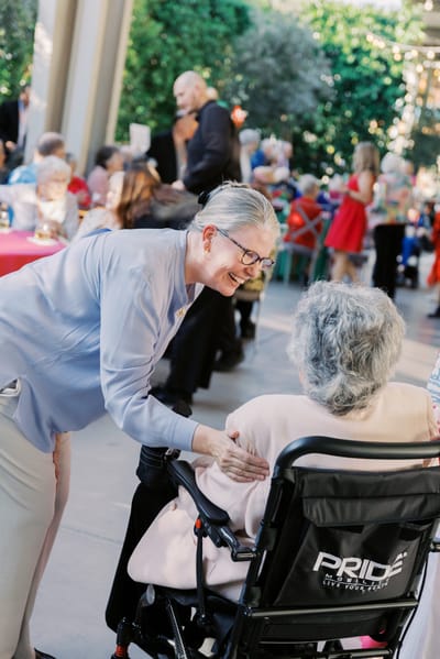 A staff member engaging with a resident at a celebration event