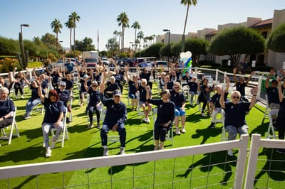 Residents celebrating outdoors with raised hands