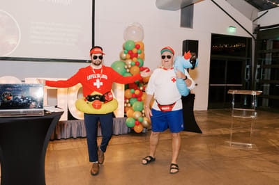 Two residents in lifeguard costumes at a festive event