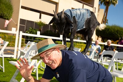Resident with a goat during an outdoor event