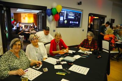 Residents participating in a bingo game at a communal table