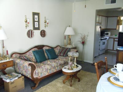 Cozy living room with floral couch and kitchen area