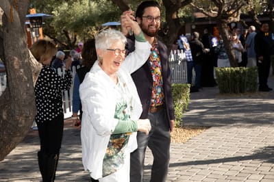 A resident dancing with a staff member outdoors