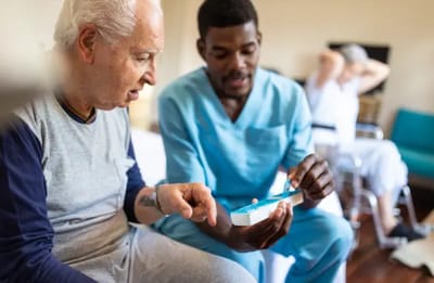 Staff assisting elderly resident with medication