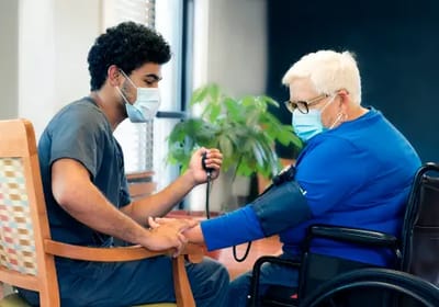 Nurse taking blood pressure of a resident