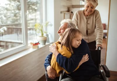 Elderly person receiving a hug from a child