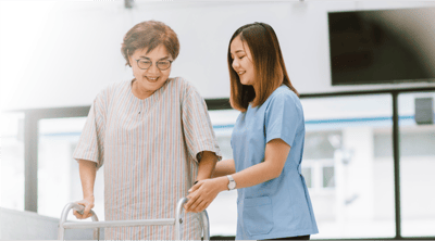 A caregiver assisting a resident with a walker.