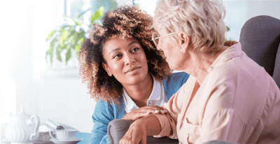 A caregiver interacting warmly with a senior resident.