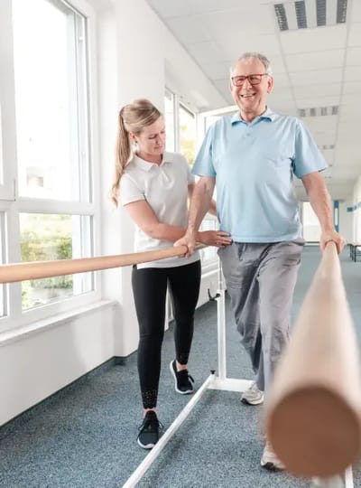 Therapist assisting senior with walking exercise